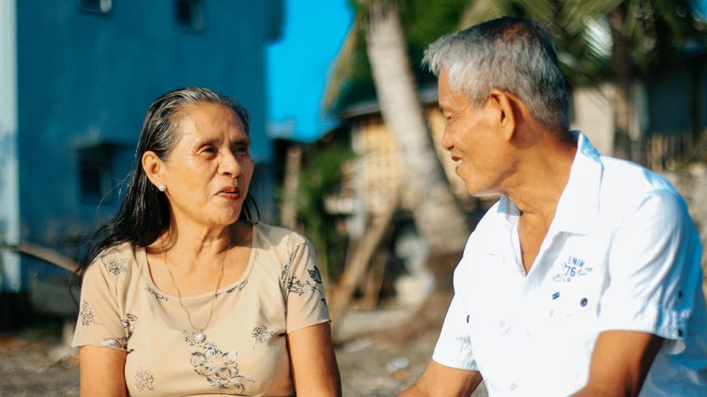 an old asian couple smiling at each other