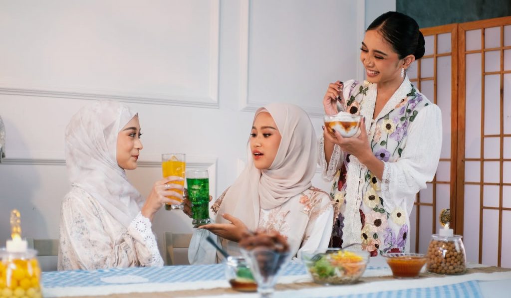 3 female muslim friends sharing drinks and desserts together