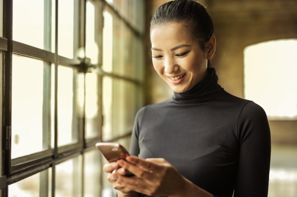 Woman in Black Turtleneck Holding Smartphone
