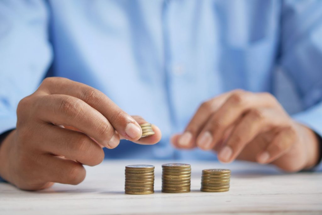 A Close-Up Shot of a Person Stacking Coins